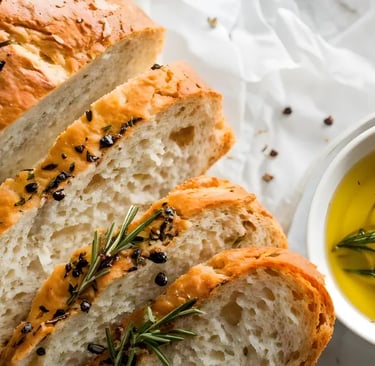 Frisches Brot neben einer Schale mit Olivenöl