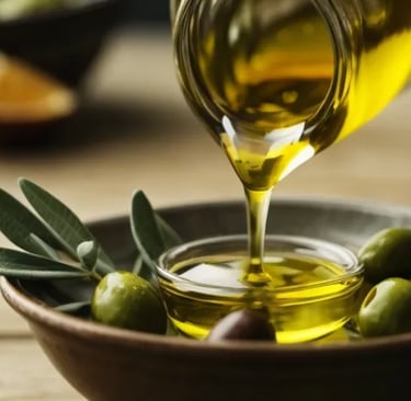 Frisches griechisches Olivenöl fließt aus einer Flasche in eine Schale – mediterrane Küche