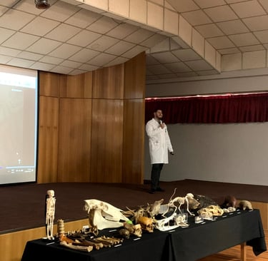 a man in a white lab coat standing in front of a presentation