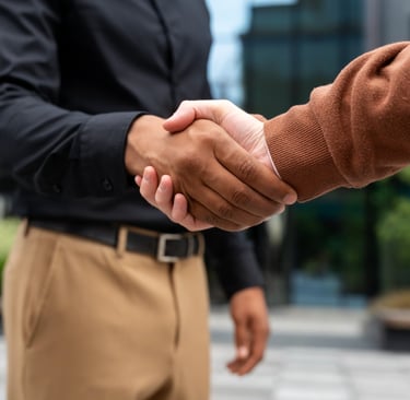 a man and woman shaking hands in front of a building