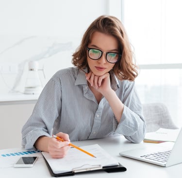 a woman sitting at a desk with a notebook and a notebook
