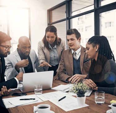 Diverse business team collaborating around a laptop, analyzing IT solutions and discussing the best technology strategy for t