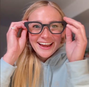 una chica sonriente poniéndose unas gafas