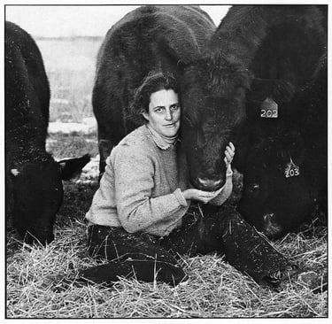 fotografía en blanco y negro de Temple Grandin con una vaca