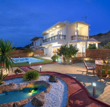 Luxury modern villa with outdoor pool, garden pond, and patio seating at sunset.