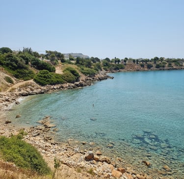 Clear turquoise water and rocky coastline at a Mediterranean beach in Crete, Greece.