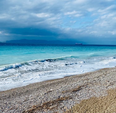 blue sea with some pebbles and waves