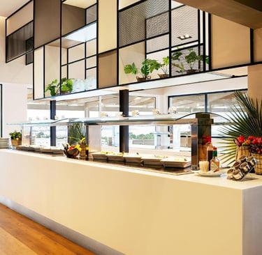 Modern hotel buffet breakfast area featuring fresh food displays and contemporary interior design.