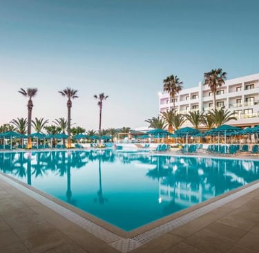 Luxury beachfront resort with a large outdoor swimming pool, lounge chairs at Mitsis Faliraki Beach 