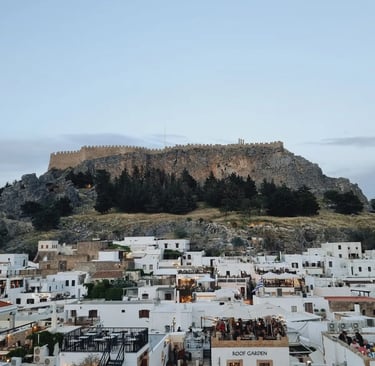 Panoramic view of the Acropolis of Lindos above white houses in Rhodes, Greece.