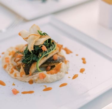 Gourmet pan-seared sea bass served over creamy puree with sauteed greens and parsnip chips.