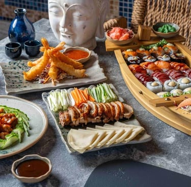 A gourmet Japanese sushi boat platter served with crispy Peking duck, shrimp tempura, and traditional sides.
