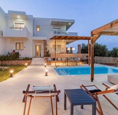 Luxury modern villa with a private swimming pool, outdoor lounge, and patio at twilight.