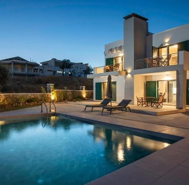 Luxury modern villa with private swimming pool and outdoor patio furniture at twilight.