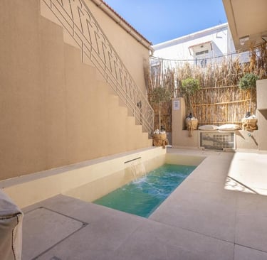 Luxury private plunge pool in a modern Mediterranean courtyard with stone tile and bamboo accents.