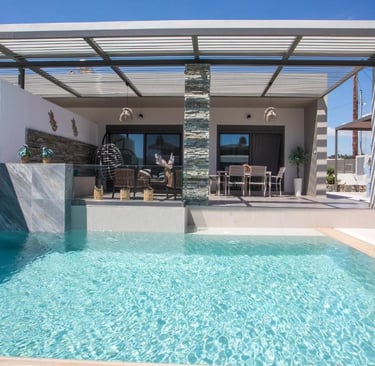Modern luxury villa with a private turquoise swimming pool, outdoor dining area, and shaded patio.