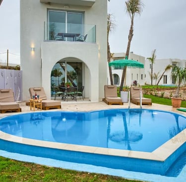 Luxury vacation villa with heart-shaped swimming pool and modern poolside lounge area.