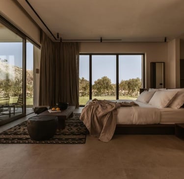 Modern minimalist luxury bedroom with floor-to-ceiling glass doors, organic linens, and desert views.