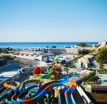Luxury beach resort with a vibrant water park and colorful water slides overlooking the blue ocean.