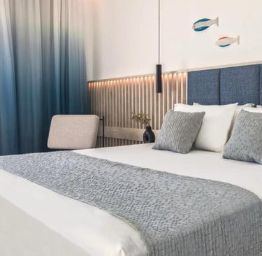 Modern luxury hotel room featuring a blue headboard, ocean views, and nautical decor.