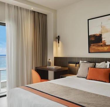 Modern luxury hotel room with king bed, ocean view balcony, and stylish contemporary decor.
