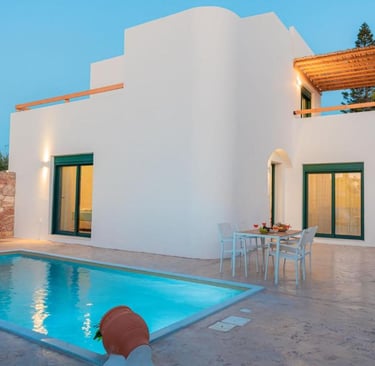 Modern Greek luxury villa with private pool, patio dining, and white architecture at dusk.