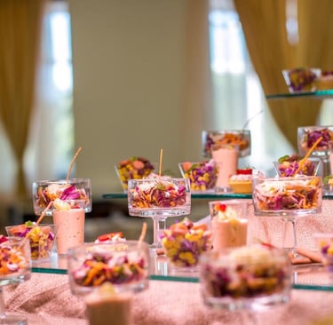 Gourmet appetizer buffet featuring small glasses of fresh vegetable salad and savory mousse.
