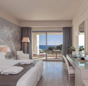 Modern luxury hotel room with twin beds and a private balcony overlooking the blue Mediterranean Sea.