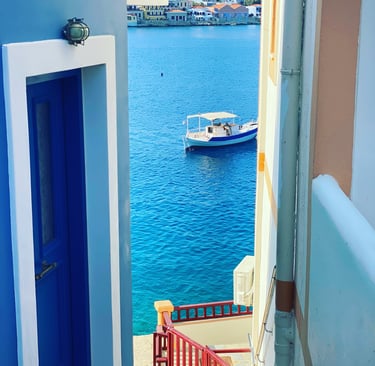 a boat on water with picture taken between houses in Chalki island