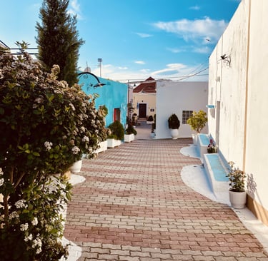 a brick walkway with a bench colorful houses in rhodes