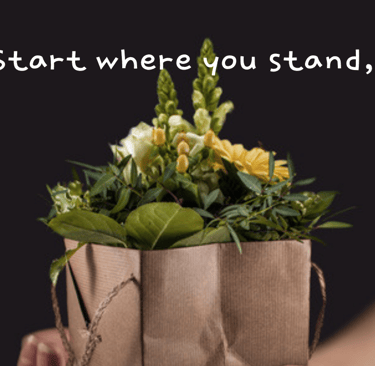 a person holding a paper bag with flowers
