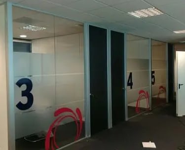 Divisorias para oficinas en cristal laminar de 55 mm. con puertas de melamina de suelo a techo