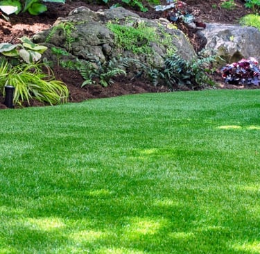 a lush green lawn with a stone wall and a stone wall