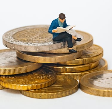 a miniature figurine of a man sitting on top of a pile of coins
