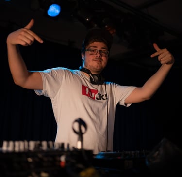 a man in a white shirt and headphones on a dj - board