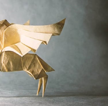 Un oriigami a forma di unicorno bianco su sfondo grigio