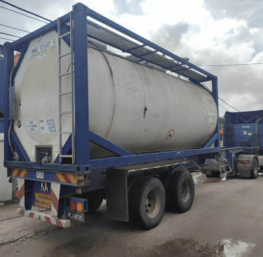 a truck with a tanking tank sitting on the side of a road