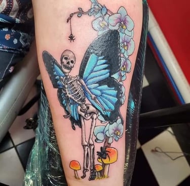 a tattoo of a skeleton and a butterfly tattoo on a woman's arm
