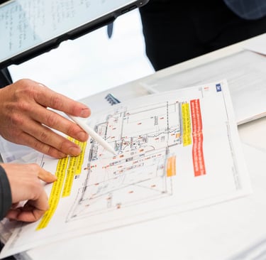 Dwie osoby konsultują projekt i nanoszą zamiany długopisem