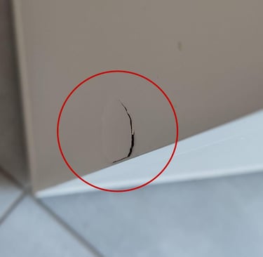 Odprysk laminatu na korpusie szafki po zbyt mocnym wbiciu kołka montażowego