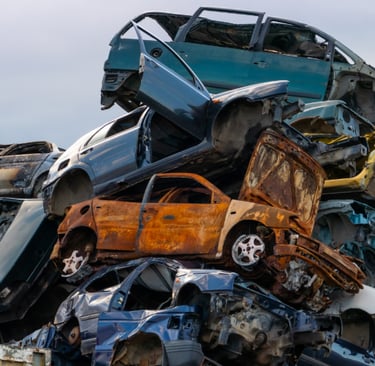 A heap of junked cars sitting on top of each other.