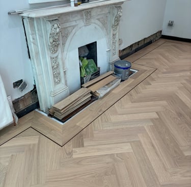 An oak herringbone floor with a double border and inlay