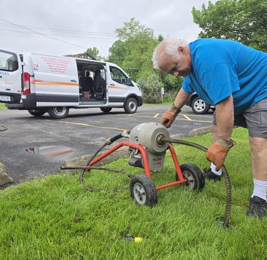 John cabling a sewer in front of his plumbing truck.