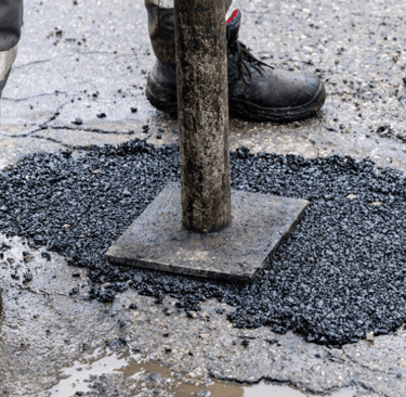 Stamping down asphalt pothole repair on roadway