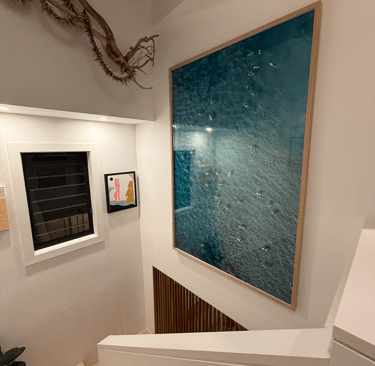 a large artwork hung in a staircase void