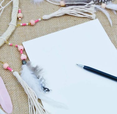 Feuille et stylo près d’un attrape-rêves, symbole d’inspiration et d’introspection selon l’esprit d’Ecl’OSons