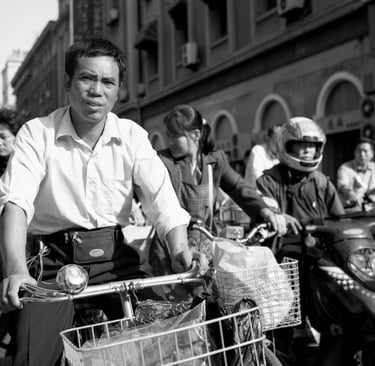 Man on bicycle waits at traffic lights in Shanghai in morning rush hour