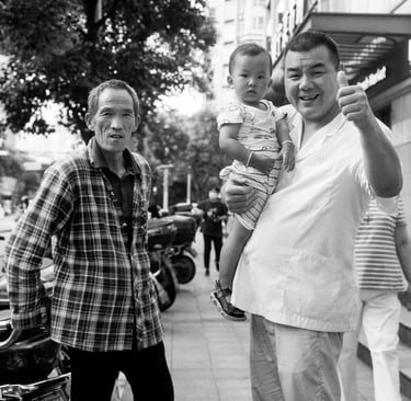 3 generations (grandfather, father and son) pose for a portrait in the street in Shanghai