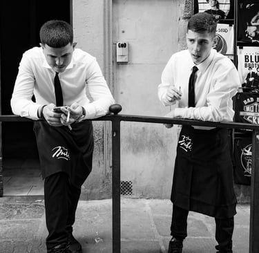 Two Italian waiters taking a cigarette break on a street in Florence