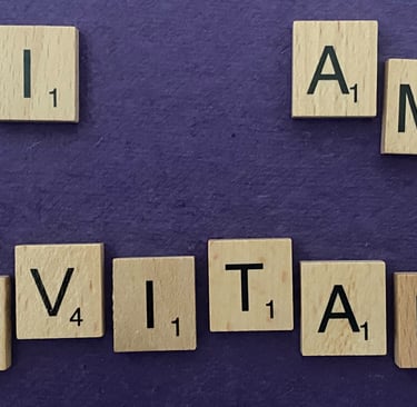 Scrabble tiles spelling out the words I am inevitable on a purple background